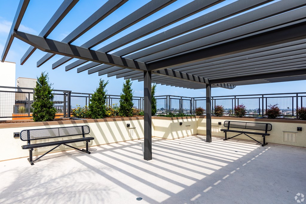 A patio with a bench and a roof.