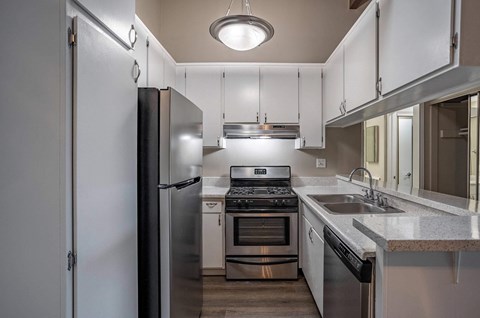 a kitchen with stainless steel appliances and white cabinets