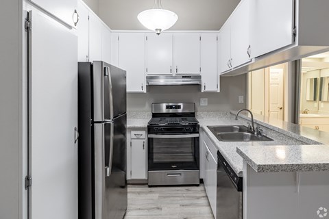 A modern kitchen with stainless steel appliances and white cabinets.