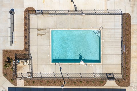 An aerial view of a rectangular pool surrounded by a fence.