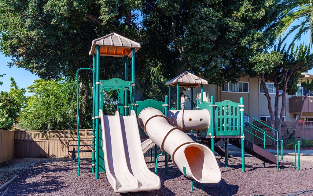a playground with two slides and a tube