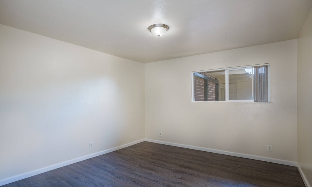 an empty living room with white walls and a window