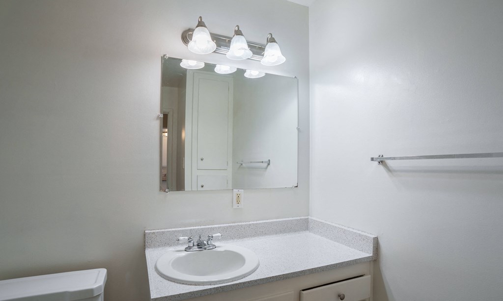 an empty bathroom with a sink and a mirror