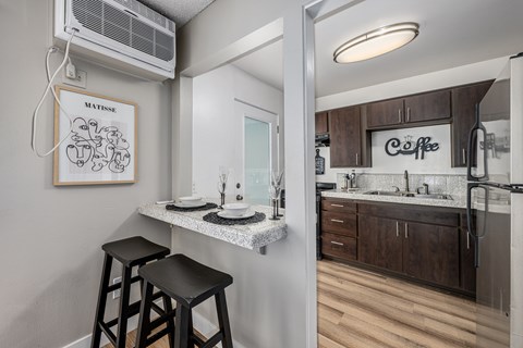 A kitchen with a fridge, a sink and a counter.