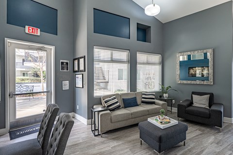 A living room with a grey couch, a coffee table, and a chair.