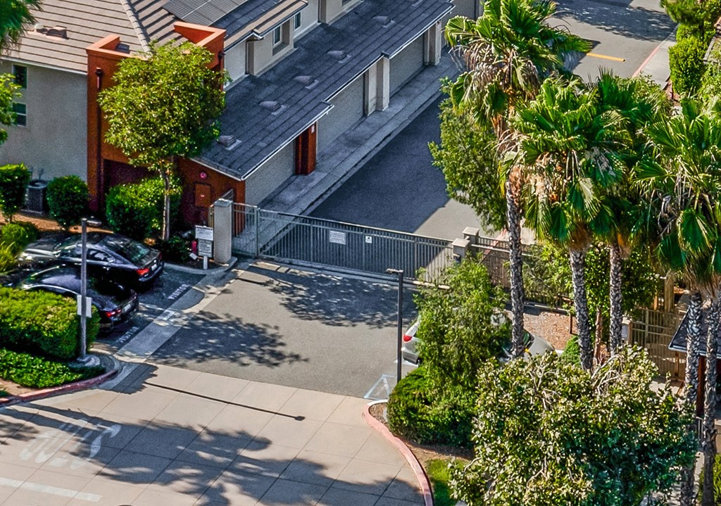 an aerial view of a parking lot with cars and palm trees