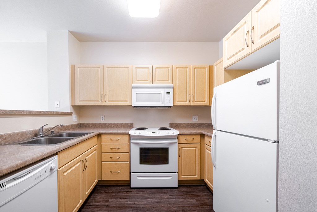 a kitchen with white appliances and wooden cabinets