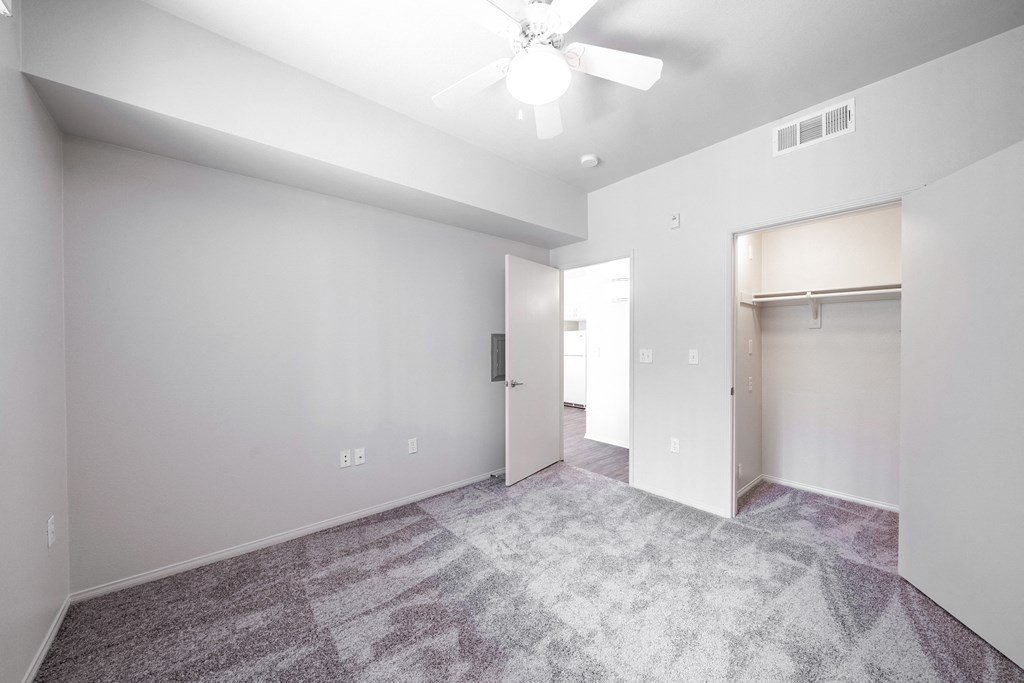 a bedroom with white walls and light grey carpet