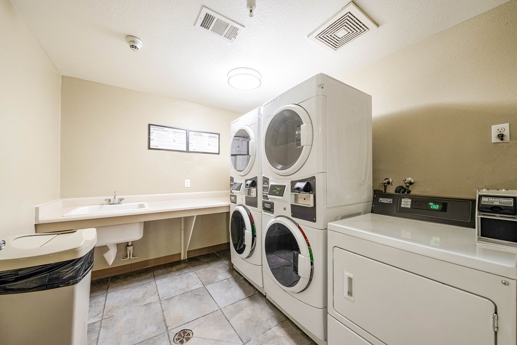 laundry facility room with a couple washer and dryer machines near counters