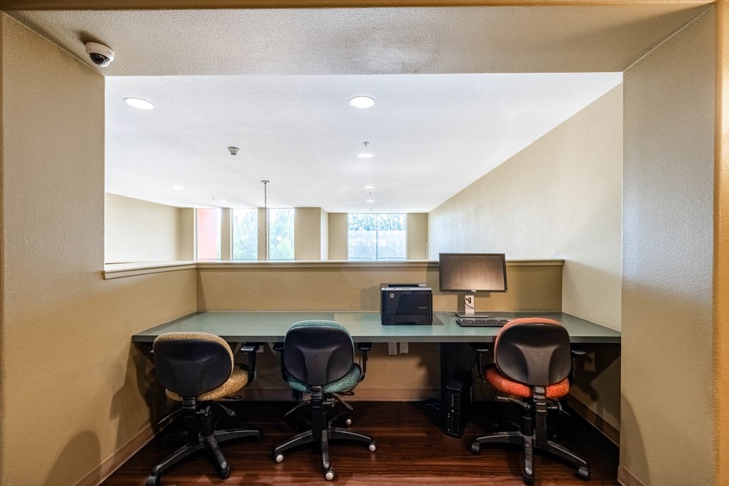 an office with a desk and chairs and a window