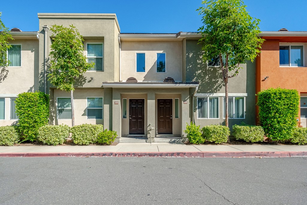 the front of a house with a street in front of it