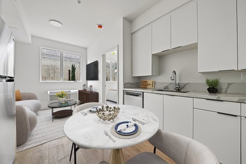 A modern kitchen with a dining table set for two.