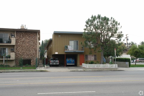 A street view of a residential area with two houses and a car parked in front of one house.