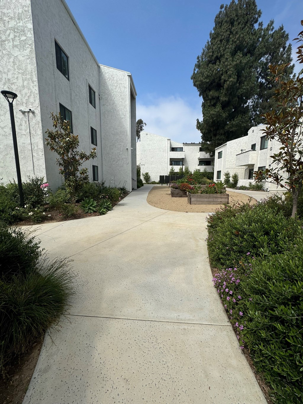 a walkway between two buildings with a bench in the middle