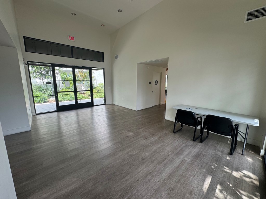 an empty club room with a table and a window