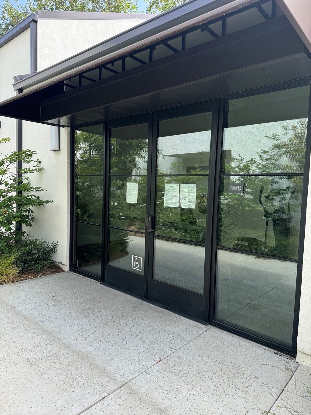 the entrance to a gym room with glass doors
