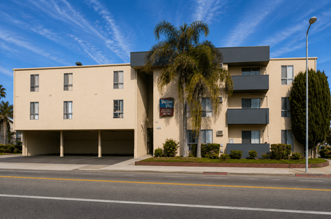 A modern building with a parking garage in front.