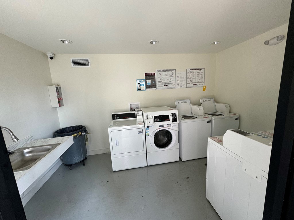 a laundry room with washers and dryers and a sink
