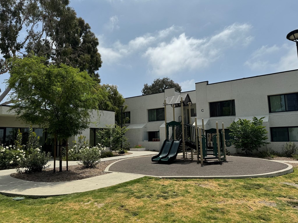 a playground in a courtyard in front of a white building