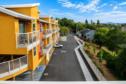 A parking lot is in front of a yellow building.