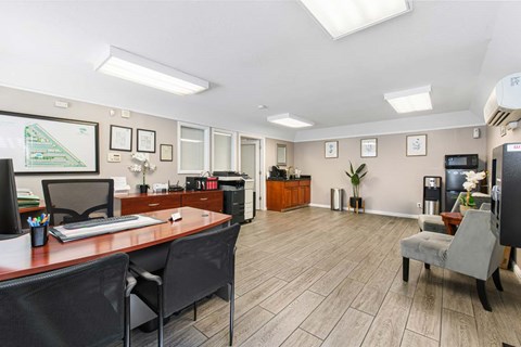 A well-lit office space with a desk, chairs, and a computer.