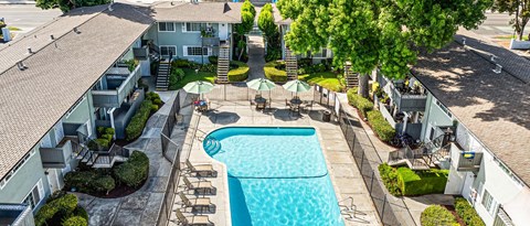 A swimming pool surrounded by a concrete patio and a grassy area.