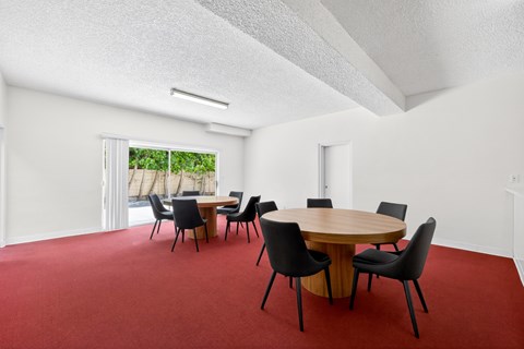 A conference room with a round table and chairs.