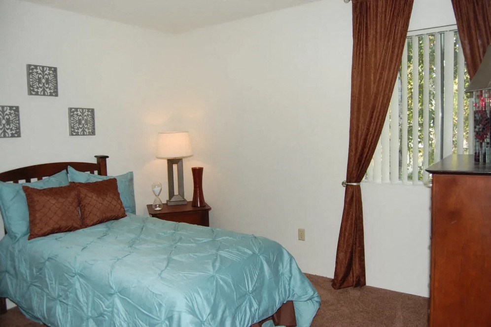 a bedroom with a bed and a window with curtains