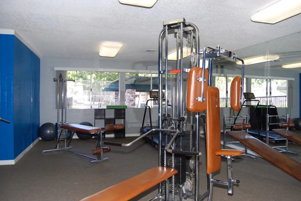 a gym with a lot of exercise equipment in a room