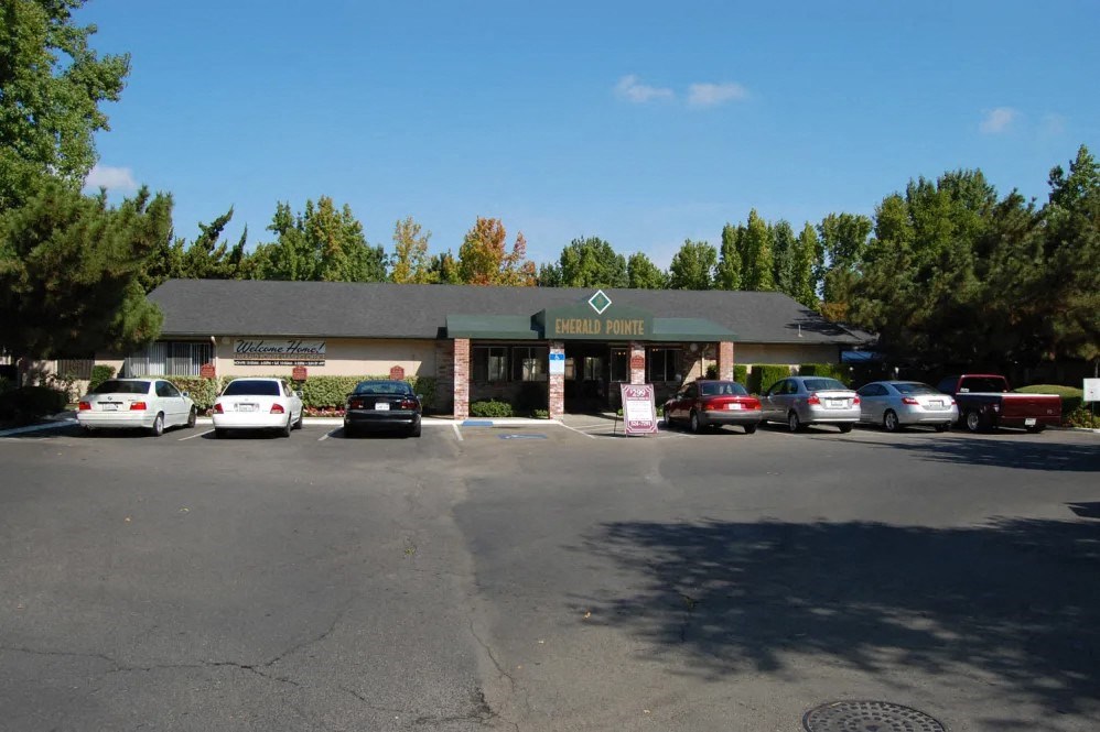 a parking lot in front of a building with cars parked