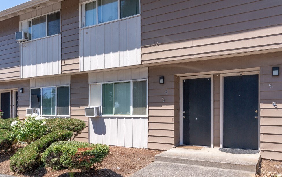 a building with two doors and a sidewalk in front of it