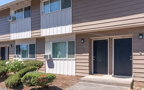 a building with two doors and a sidewalk in front of it