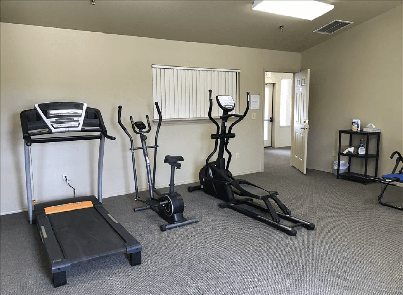 a room with two exercise machines and a treadmill