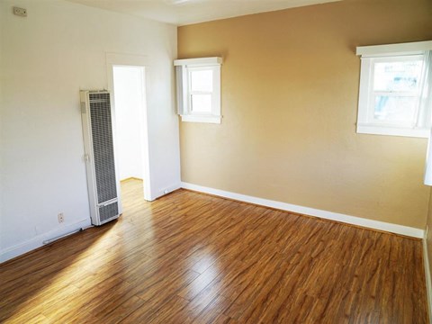 an empty living room with a hard wood floor
