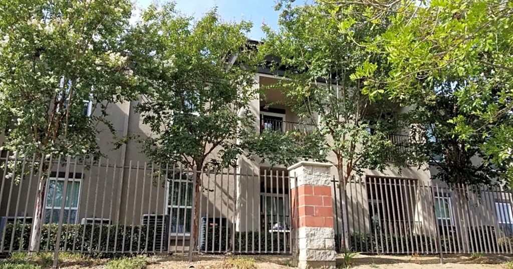 an apartment building with a fence in front of it