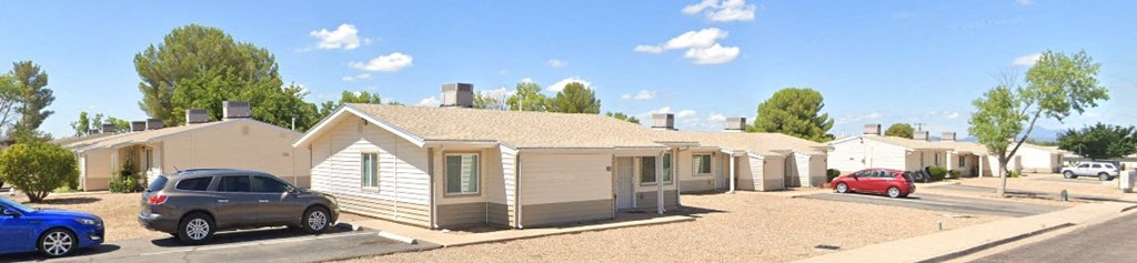 a group of houses with cars parked in front of them