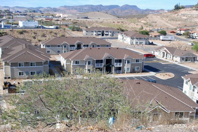an aerial view of a subdivision with houses and mountains in the background