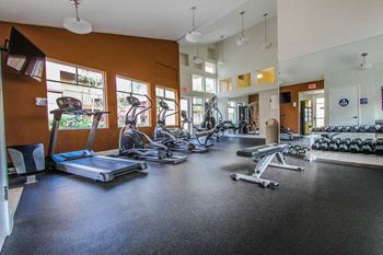 a gym with cardio equipment and weights on the floor at The Marquee Apartments, North Hollywood, CA