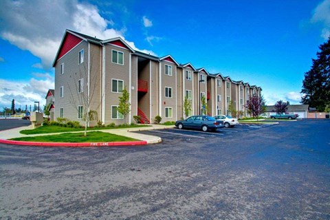 Apartment complex with a blue car parked in front.