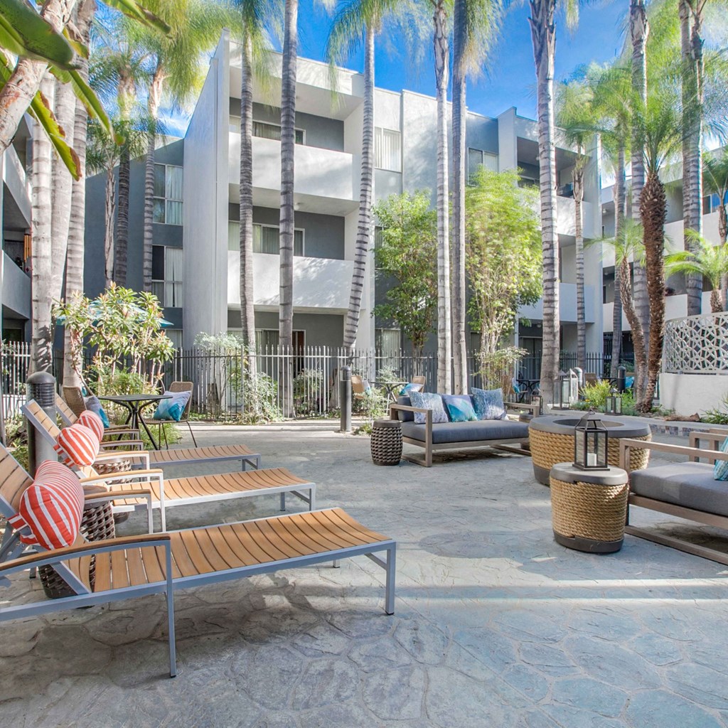 A modern building with a courtyard surrounded by palm trees.