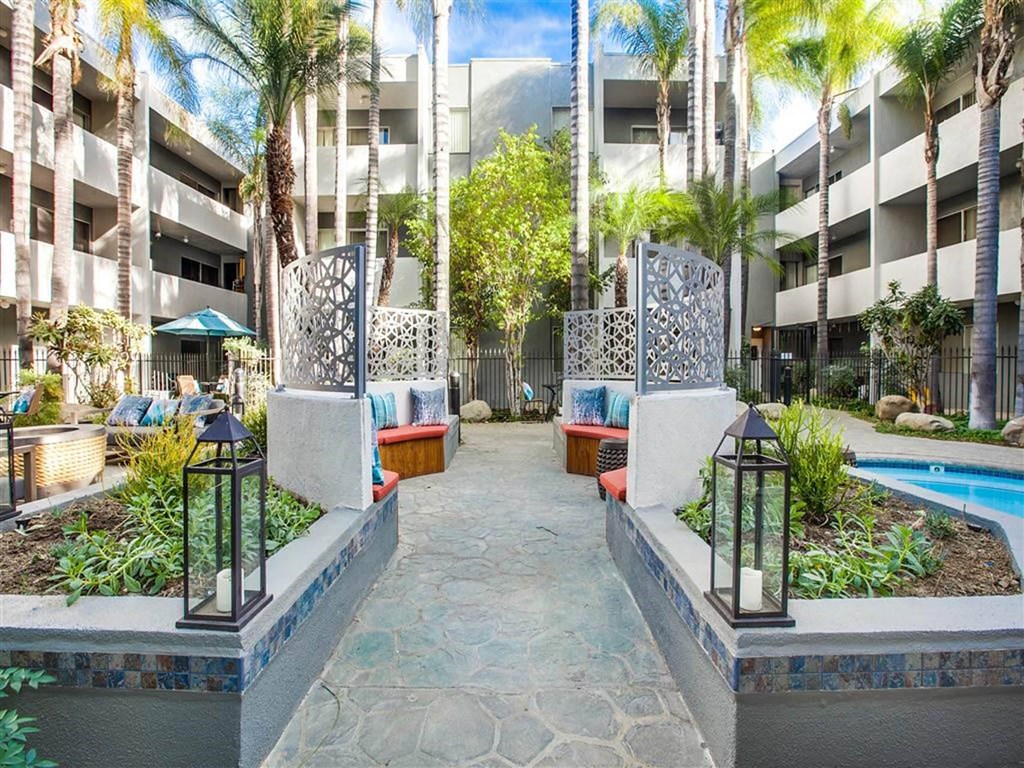 A courtyard with a pool surrounded by buildings and trees.