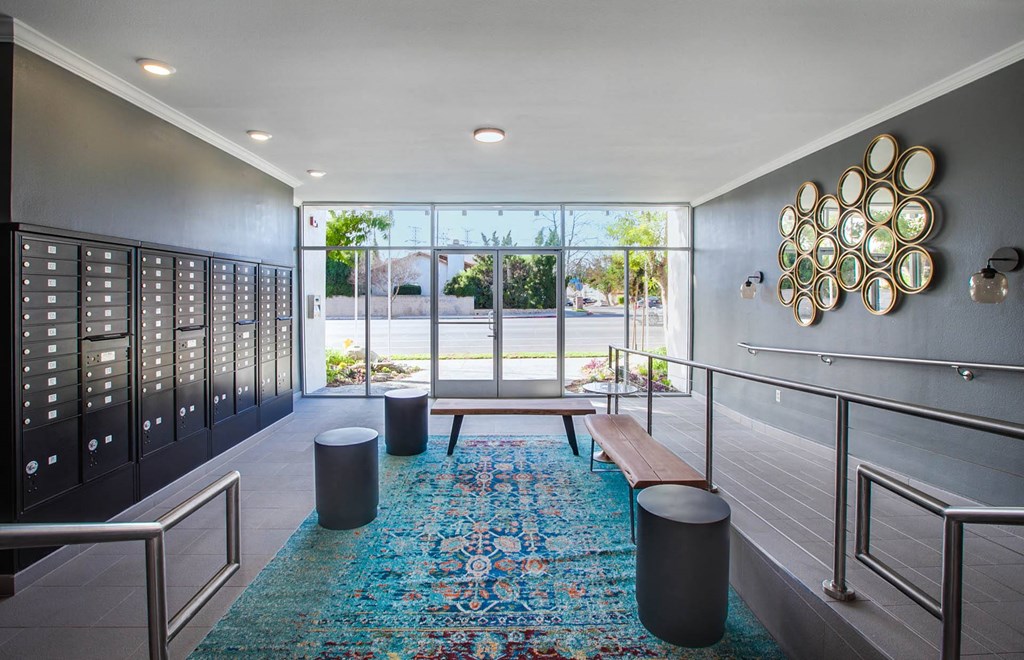 A hallway with a blue rug and a wall hanging of plates.