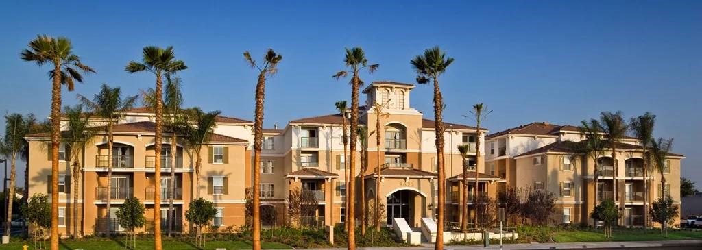 A large building with palm trees in front of it.
