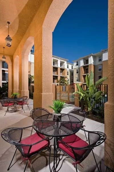 A patio with a table and chairs is surrounded by arches.