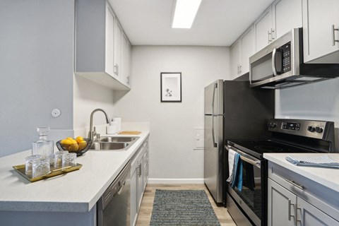 A modern kitchen with a black refrigerator and stove.