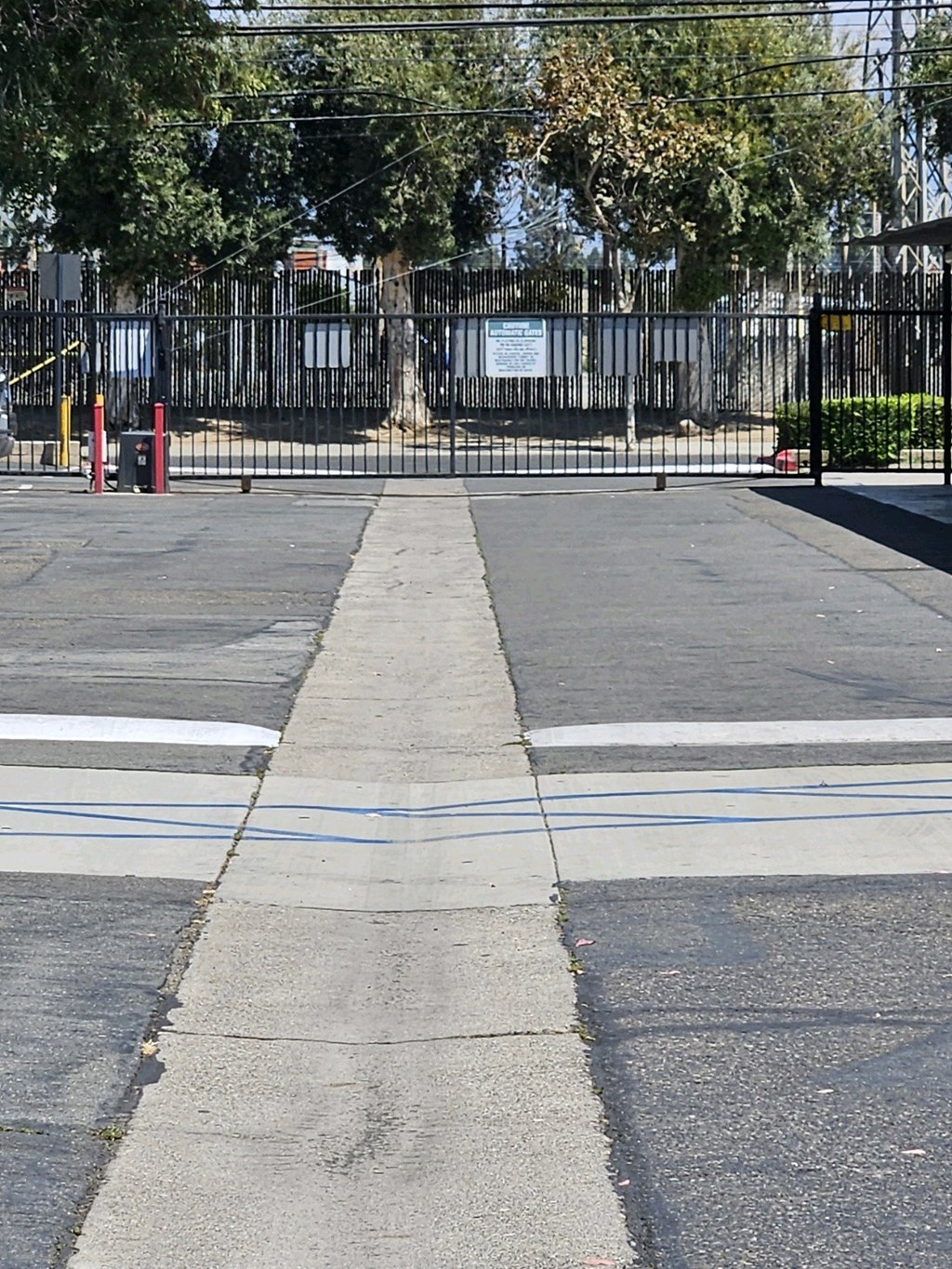 a street with a black fence and a cross walk