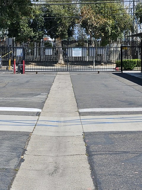 a street with a black fence and a cross walk