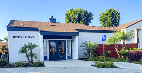 A rental office building with a parking sign in front.