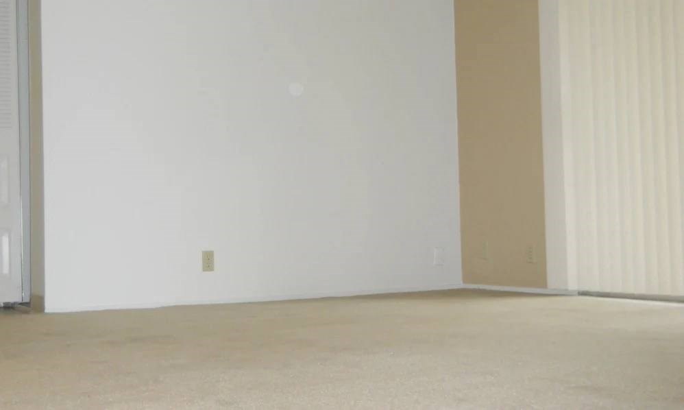 an empty living room with a white wall