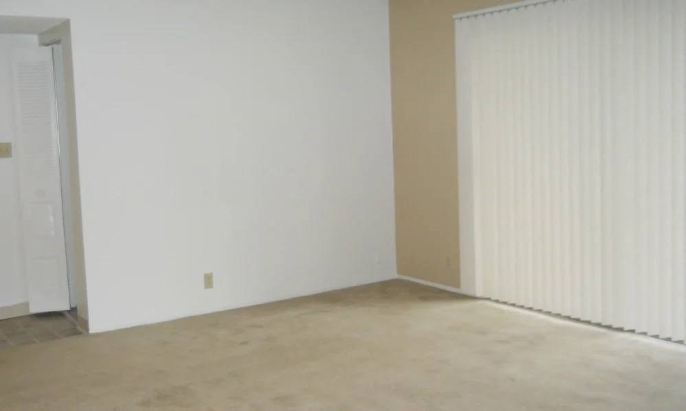 an empty living room with white walls and a concrete floor